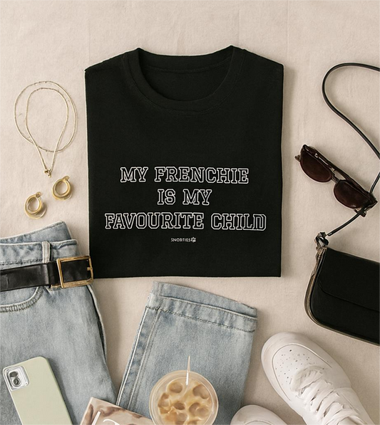 Women's T-shirt from Snorties with "My Frenchie is my favourite child" printed design, flat lay on a table.